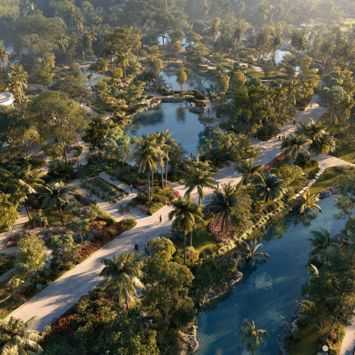 Aerial view of a landscaped park with winding pathways, lush trees, flower beds, and multiple water features including ponds and a river.