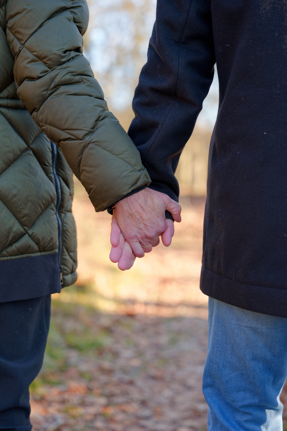 Twee mensen die elkaar vasthouden tijdens een wandeling buiten.