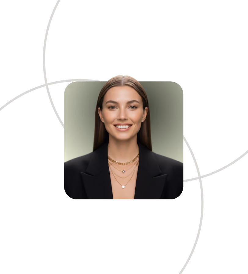 Smiling woman with long brown hair wearing black blazer and layered gold necklaces on green background.