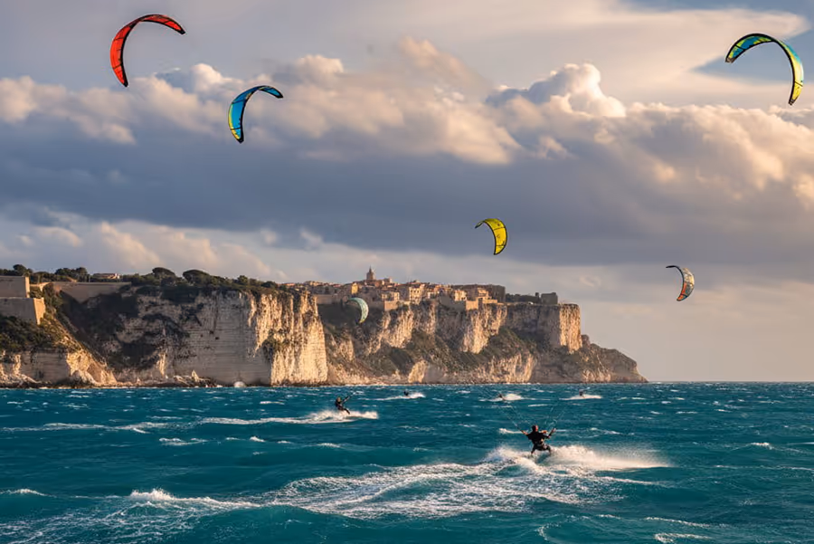 Mehrere Kitesurfer an Küste