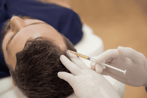 Injecting a needle into a man's hair.
