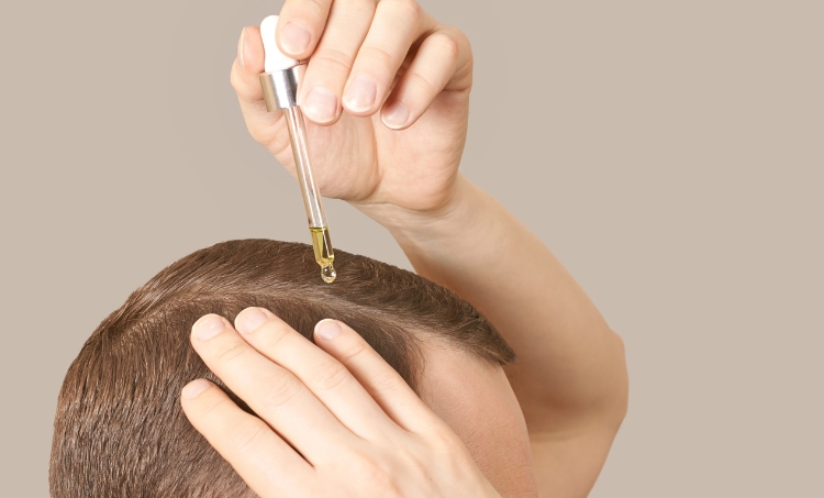 Dripping hair oil on scalp.