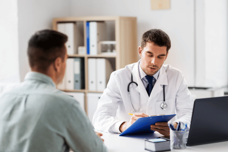 Doctor reviewing paperwork with a male patient during a medical consultation