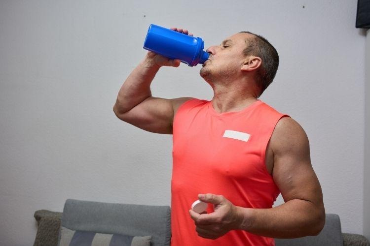 Man consuming pre workout supplement drink to support energy levels and healthy testosterone levels in men’s health routine