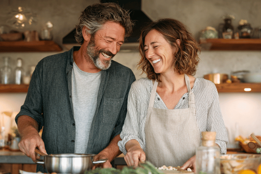 Happy middle-aged couple cooking a healthy meal together at home.