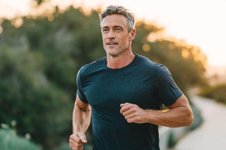 Middle-aged man running outdoors as part of a regular exercise routine that supports overall health.