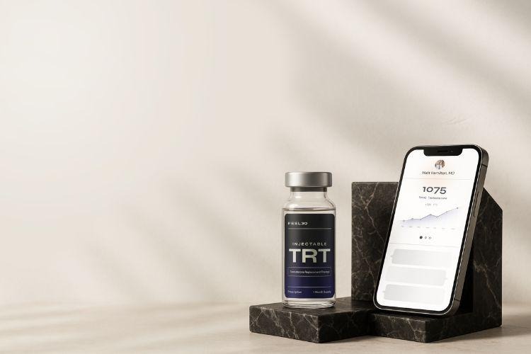 Feel30 injectable TRT vial beside a smartphone displaying a testosterone levels chart