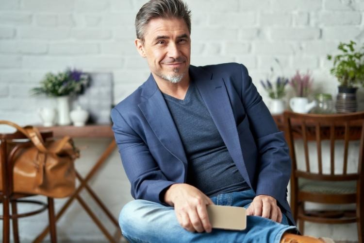 Man in blue suit jacket and blue t-shirt with grey hair.
