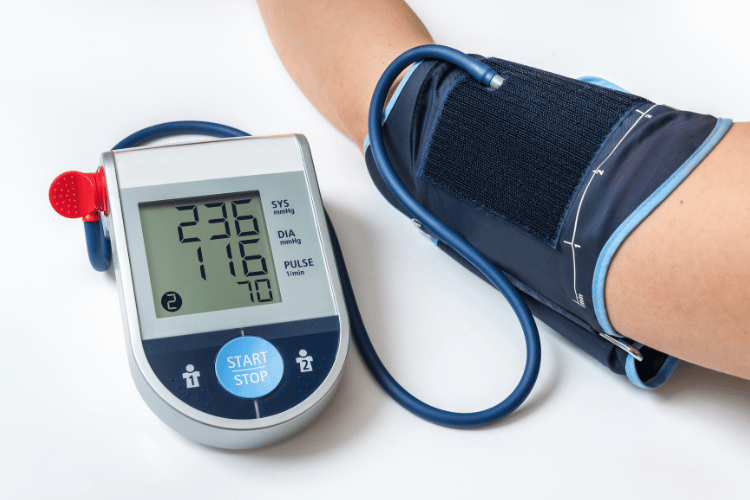 Upper arm blood pressure monitor displaying a high systolic and diastolic BP reading during a home health check