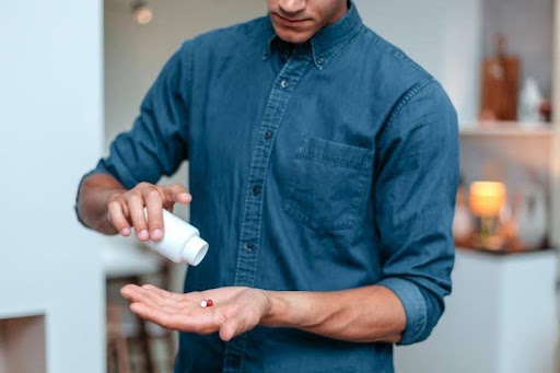 Man preparing to take oral medication.