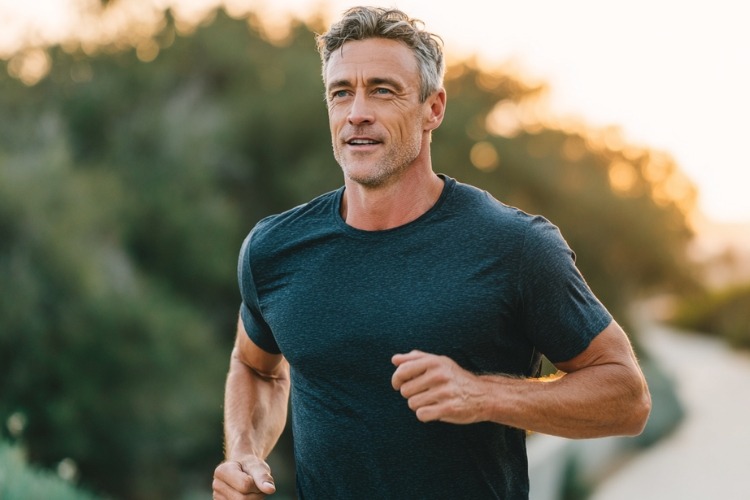 Fit middle-aged man jogging outdoors to maintain muscle and strength after age 60.