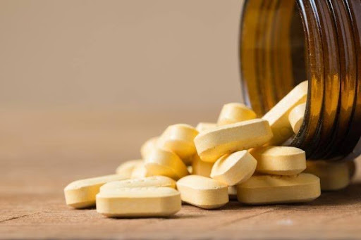Vitamin supplements spilling from a bottle for healthy aging and muscle support.
