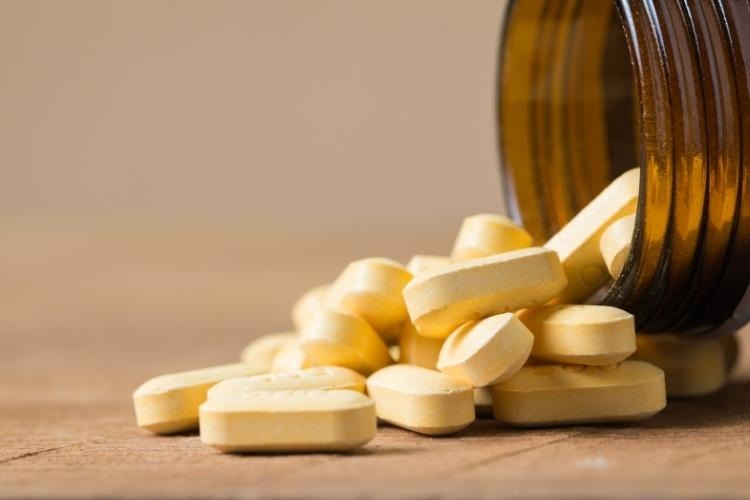 close-up of vitamins coming out of a bottle