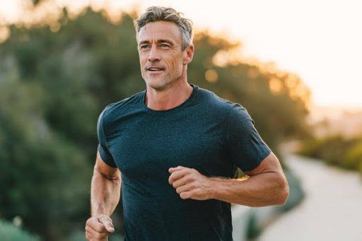 Fit middle-aged man running outdoors to maintain muscle mass with age.
