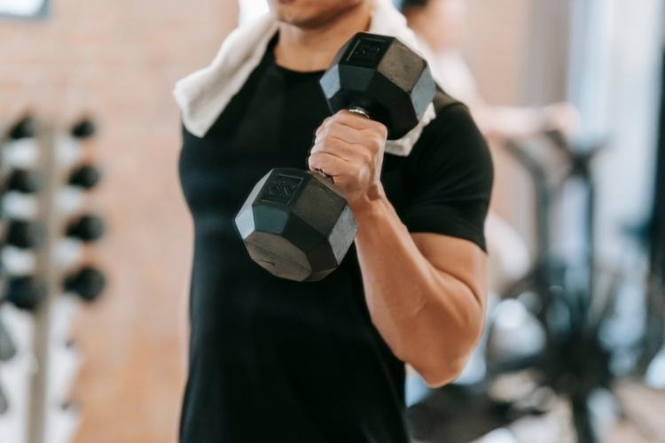 Man lifting a dumbbell during a strength training workout.