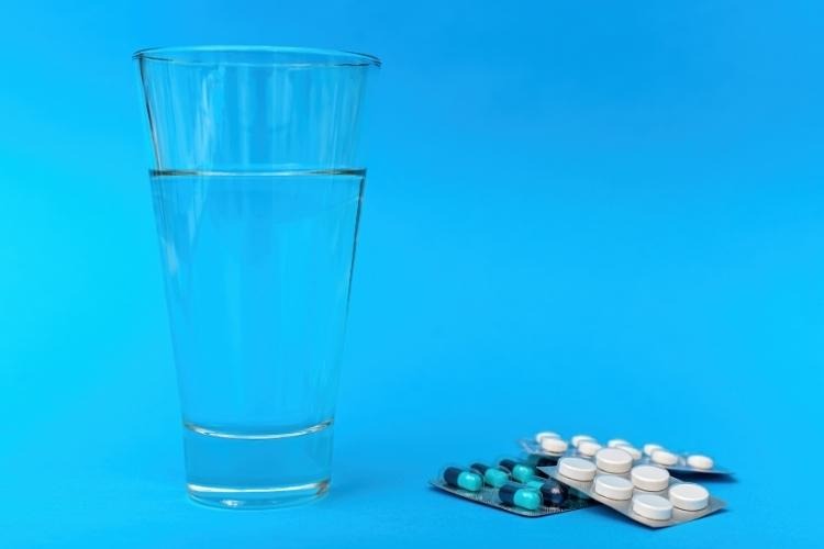 Glass of water and pills.