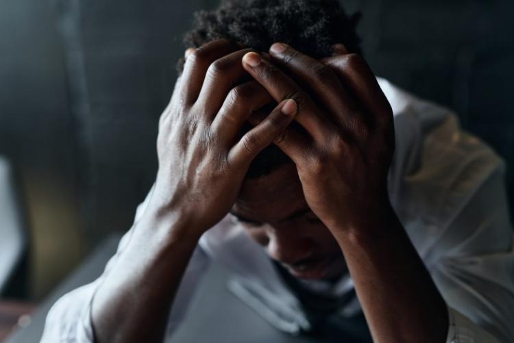 Man with severe depression holding his head in his hands.