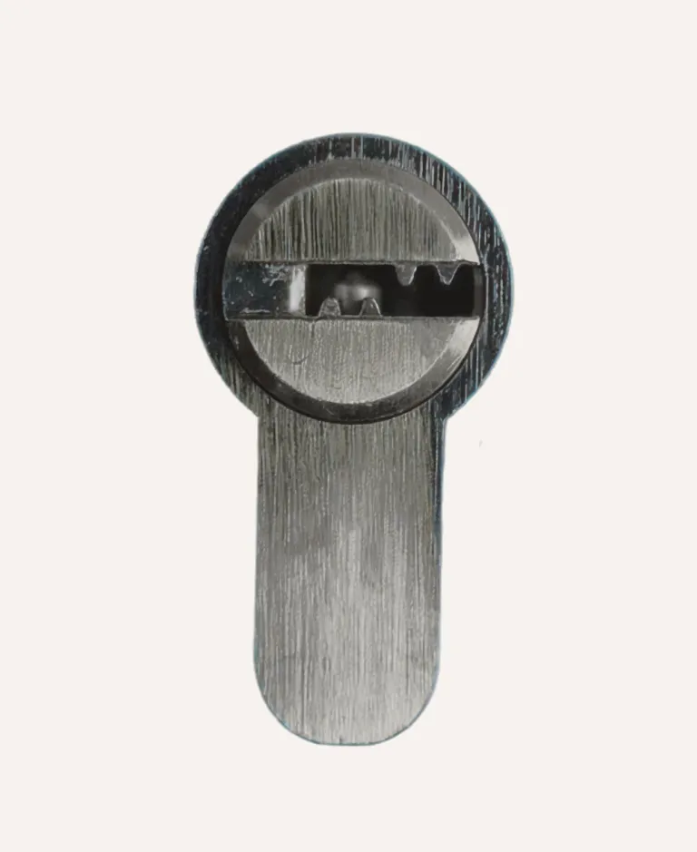 Close-up of a metal keyhole cylinder for a lock against a plain background.