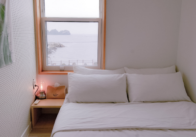 '제주늘보의오후' 프렌즈룸의 객실 창에서 보이는 바다의 모습.
The view of the sea from the room window of the Friends Room in the 'JEJUNEULBO'.