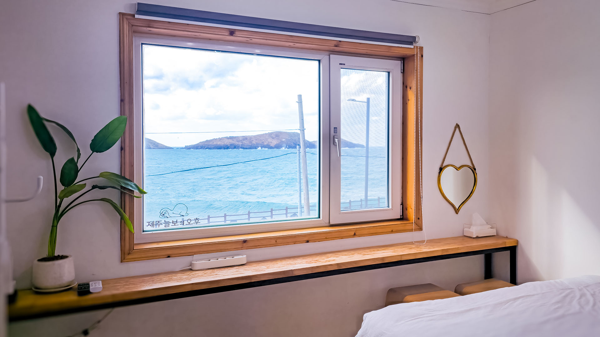 '제주늘보의오후' 패밀리룸 객실 창으로 보이는 차귀도의 모습. 'JEJUNEULBO' The view of Cha Guido Island seen through the family room window.