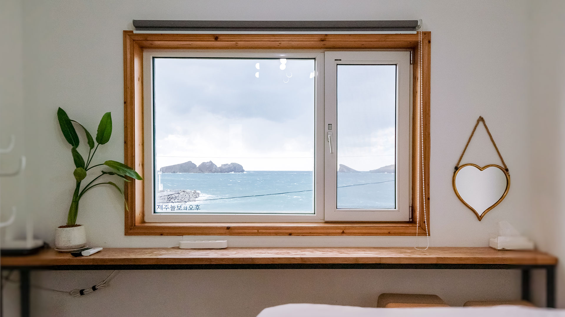 "제주늘보의오후" 패밀리룸 큰방 정면 창에서 보이는 바다의 풍경, 용수항의 방패제와 차귀도가 있는 바다의 풍경이다. 'JEJUNEULBO' is the view of the sea from the front window of the main room of the family room, and the view of the sea with Yongsu Port's shield and Cha Guido Island.
