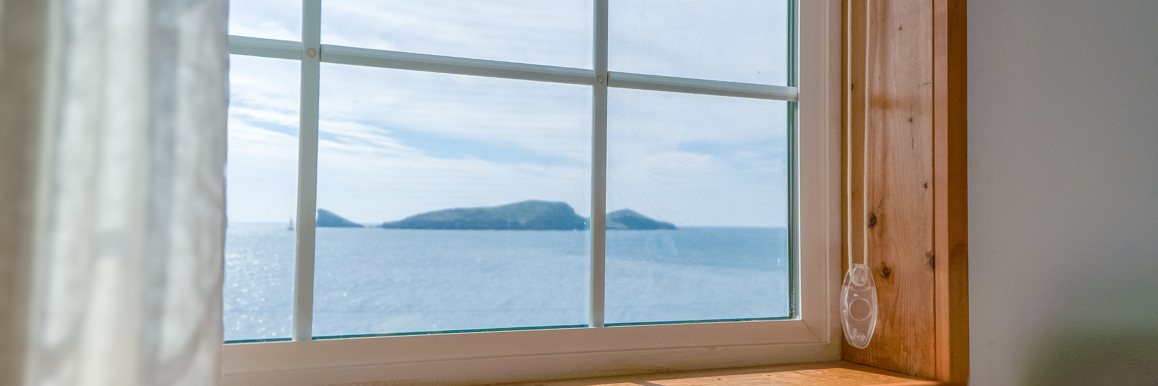 '제주늘보의오후' 3층 루프룸 창밖으로 보는 바다와 차귀도의 모습. 
The view of the sea and Cha Guido Island looking out the window of the roof room on the third floor of 'JEJUNEULBO'