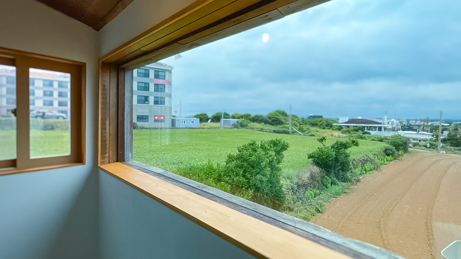 '제주늘보의오후' 2층 듀플렉스룸 입구쪽 창문에서 본 풍경. The view from the entrance window of the duplex room on the second floor of 'JEJUNEULBO'.
