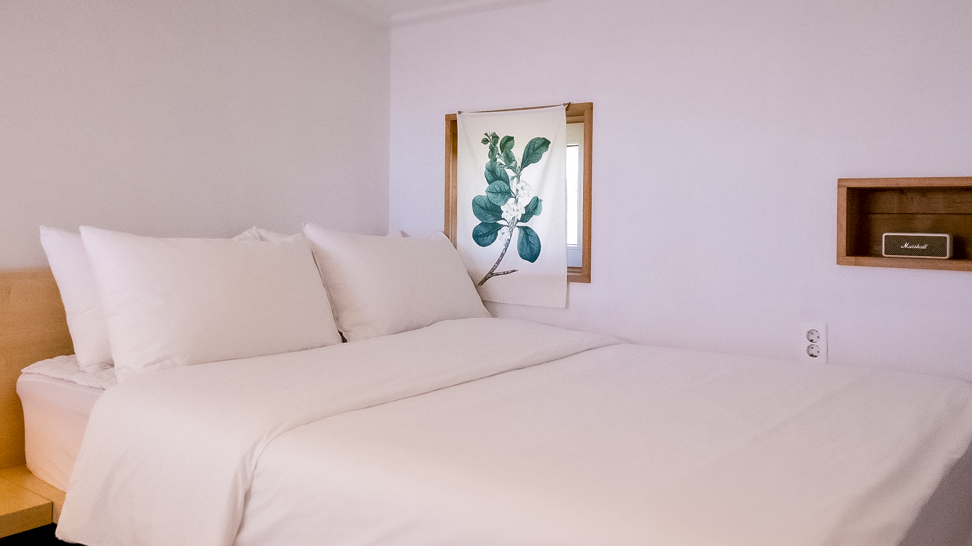 '제주늘보의오후' 2층 듀플렉스룸 복층 침실의 침대 주변 모습. The view around the bed in the duplex room double-decker bedroom on the second floor of 'JEJUNEULBO'.