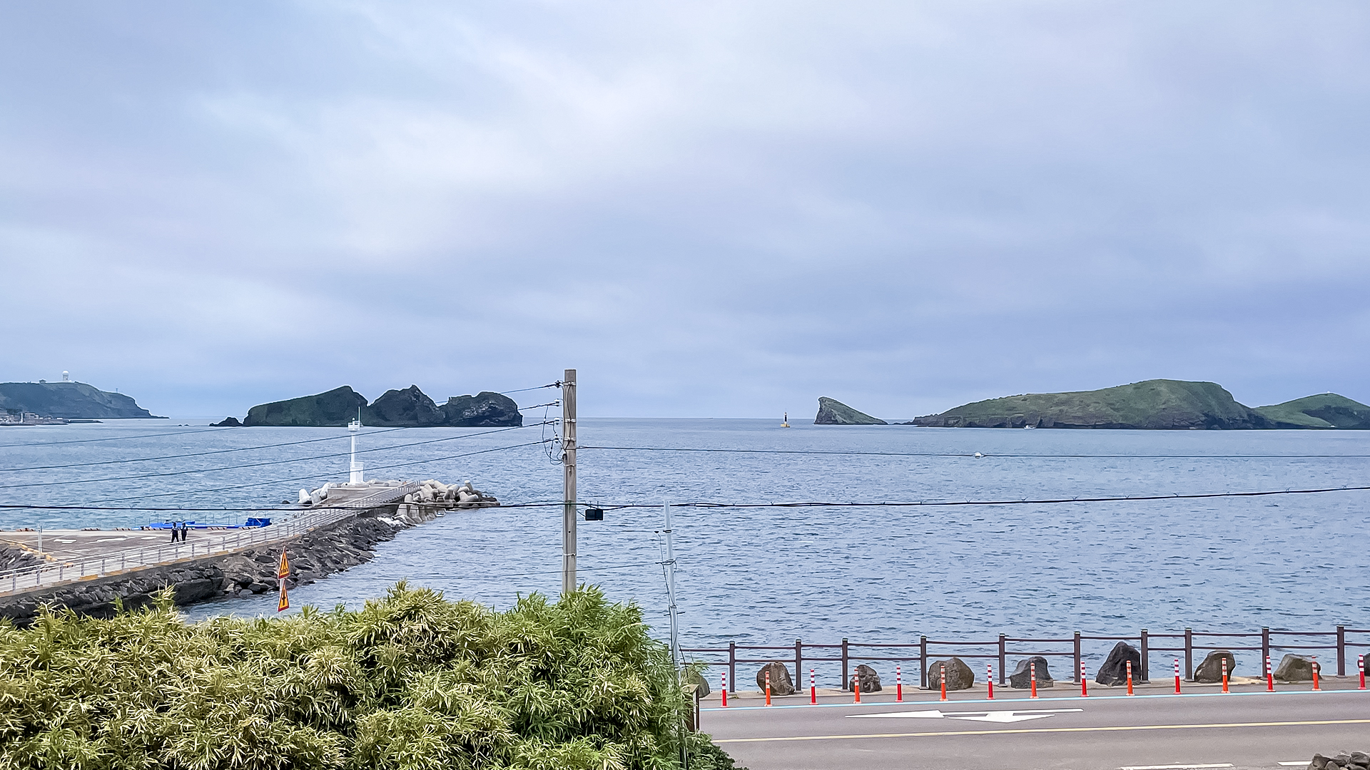 '제주늘보의오후' 듀플렉스룸 창문으로 바라보는 차귀도가 있는 바다의 풍경. The view of the sea with Cha Guido Island looking through the duplex room window of 'JEJUNEULBO'.