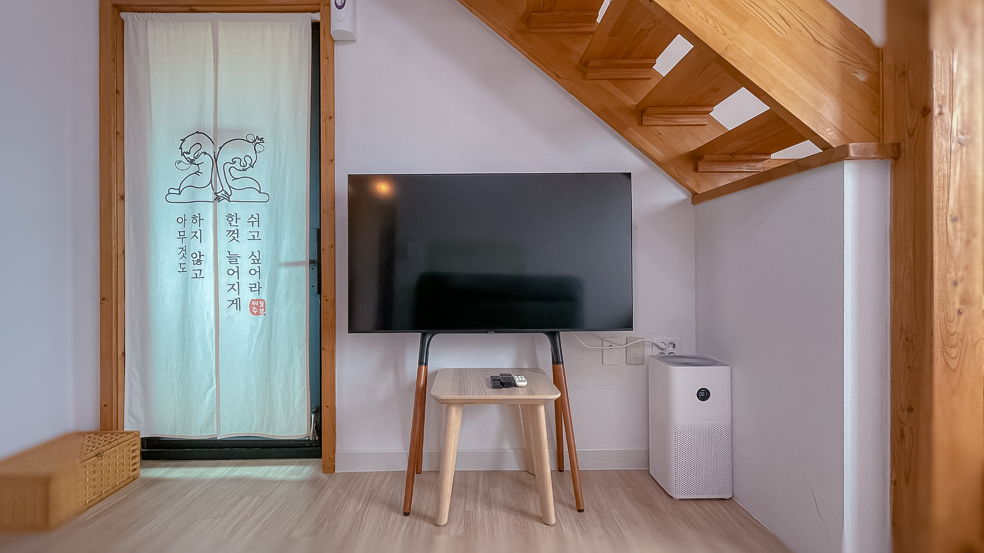 '제주늘보의오후' 2층 듀플렉스룸 텔레비전과 출입문 방향 모습. A view of the duplex room television and the doorway on the second floor of 'JEJUNEULBO'.