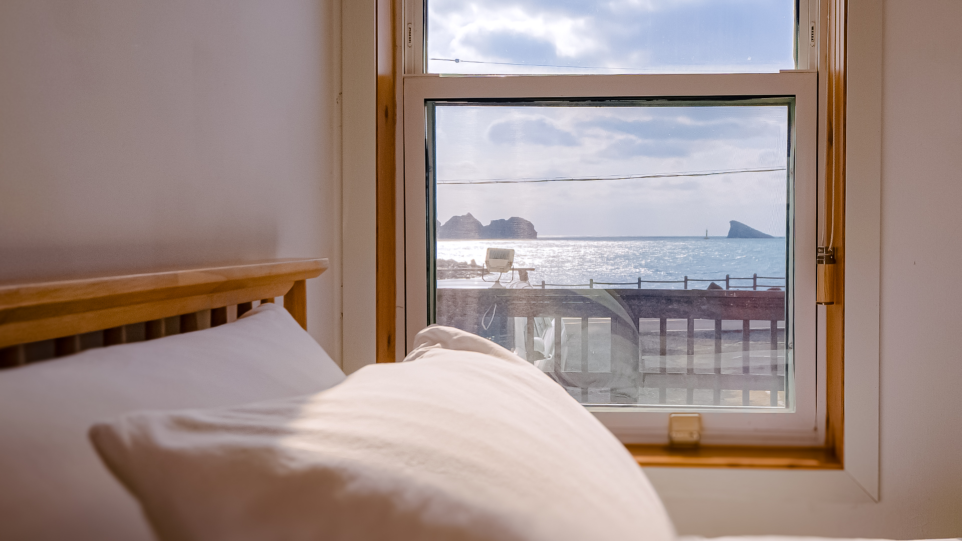 '제주늘보의오후' 1층 트윈룸 침대 뒤쪽으로 창문이 있으며, 바다가 바로 보이는 장면.
'JEJUNEULBO' has a window behind the twin-room bed on the first floor, and a scene where you can see the sea right away.