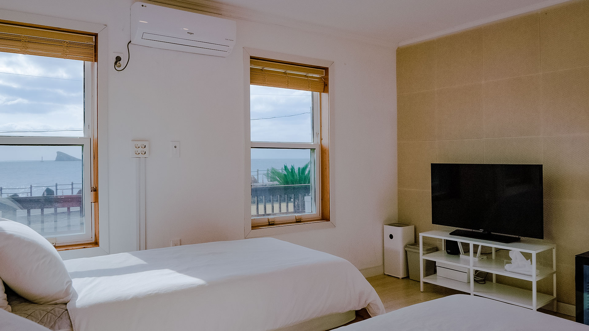 '제주늘보의오후' 1층 트윈룸 일부 전경 침대와 창문 텔레비전이 있는 장면. 'JEJUNEULBO' scene with some foreground beds and window televisions on the first floor of the twin room.