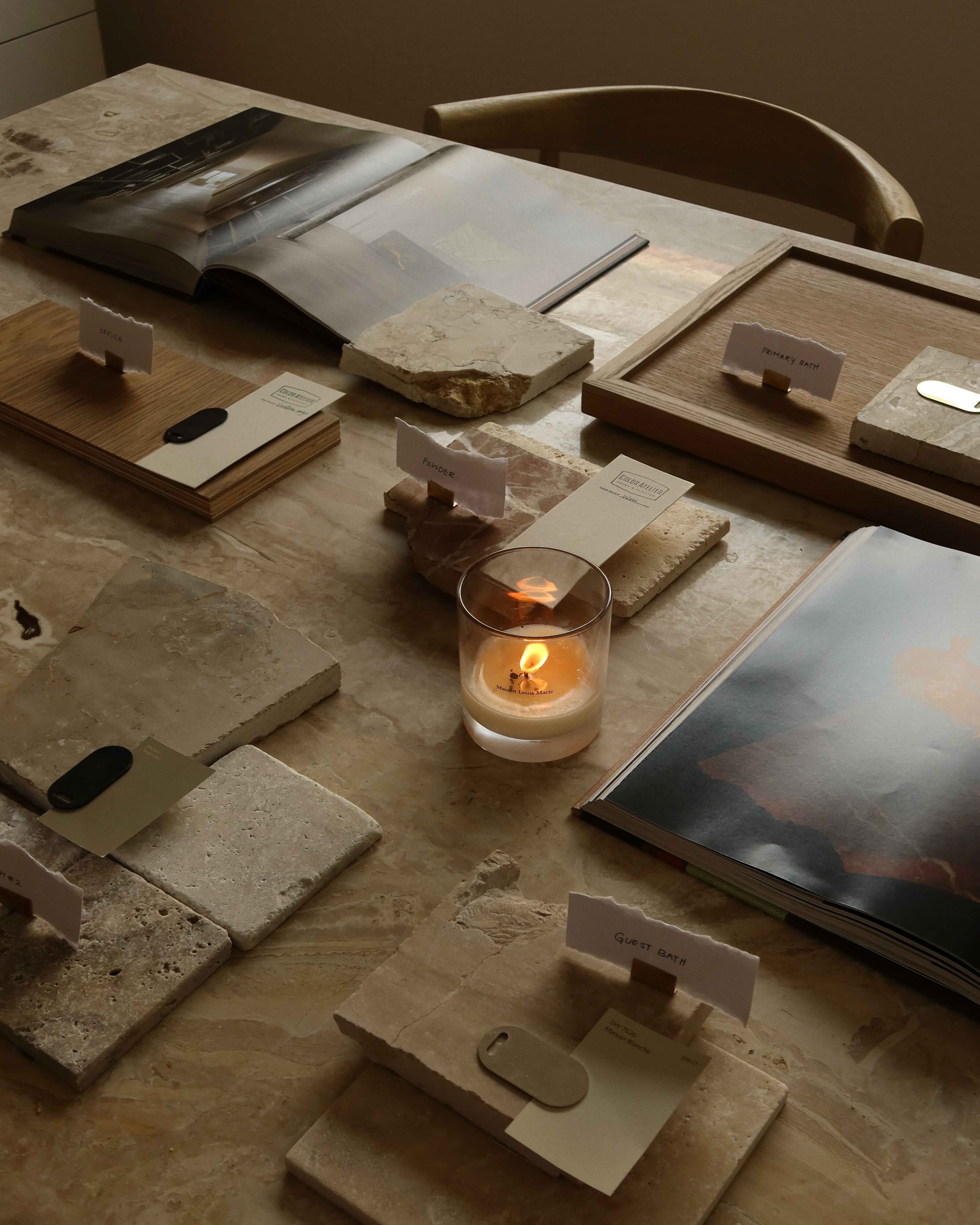Interior material selection session at Eské Studio showing stone and wood samples with design reference books