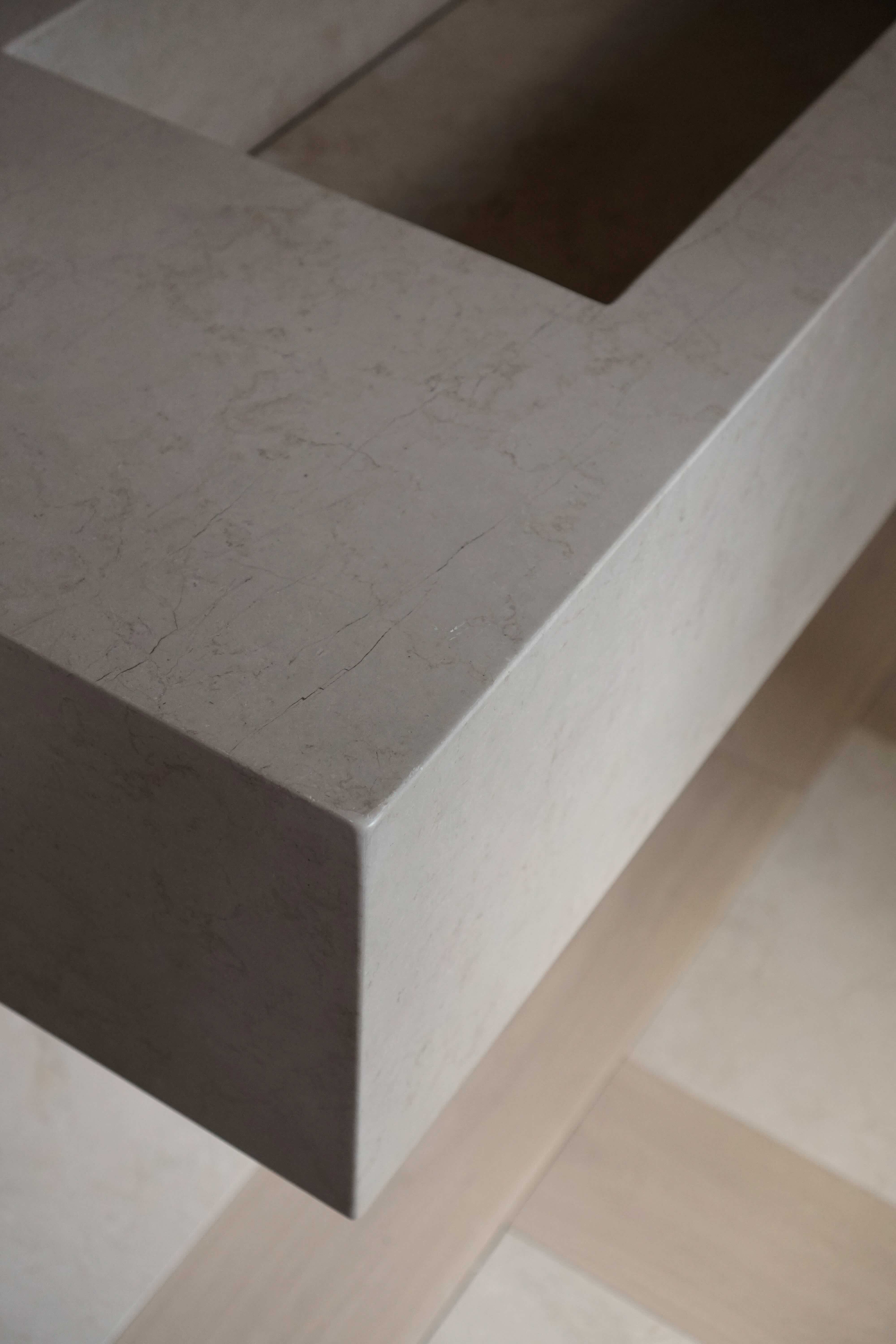 Custom Crema Marfil marble floating vanity with integrated stone sink, Eské Studio project