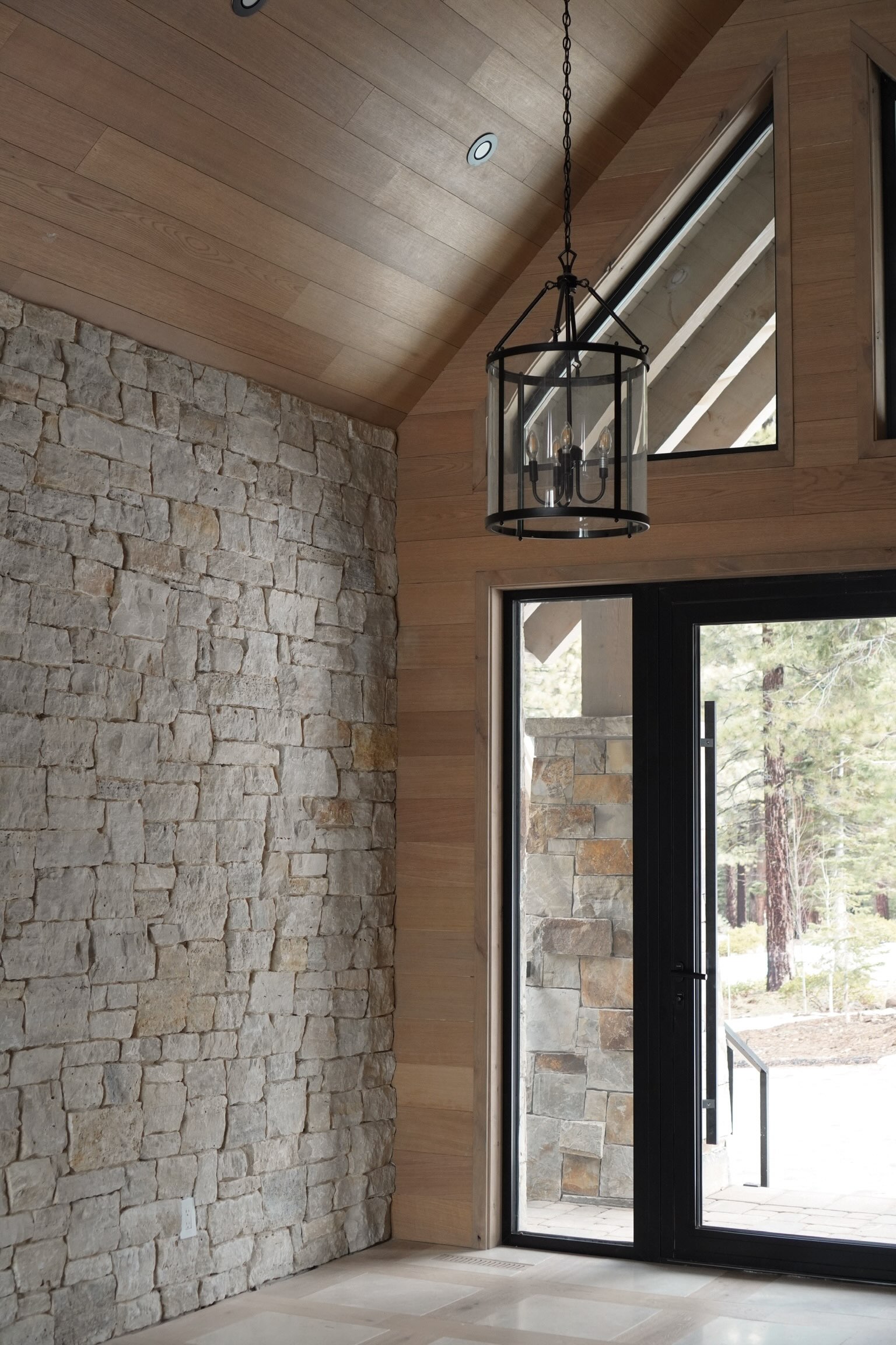 Custom stone wall and wood ceiling in Lake Tahoe chalet entryway, Eské Studio project
