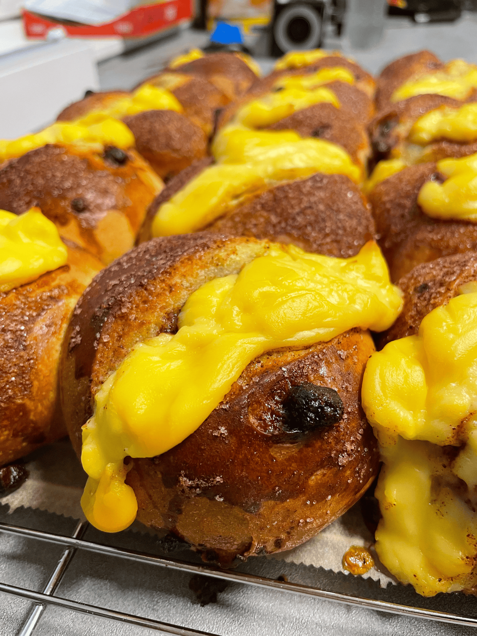 Innendørs spisested med røde vegger, svarte sittebenker, trebord og hengende lamper.