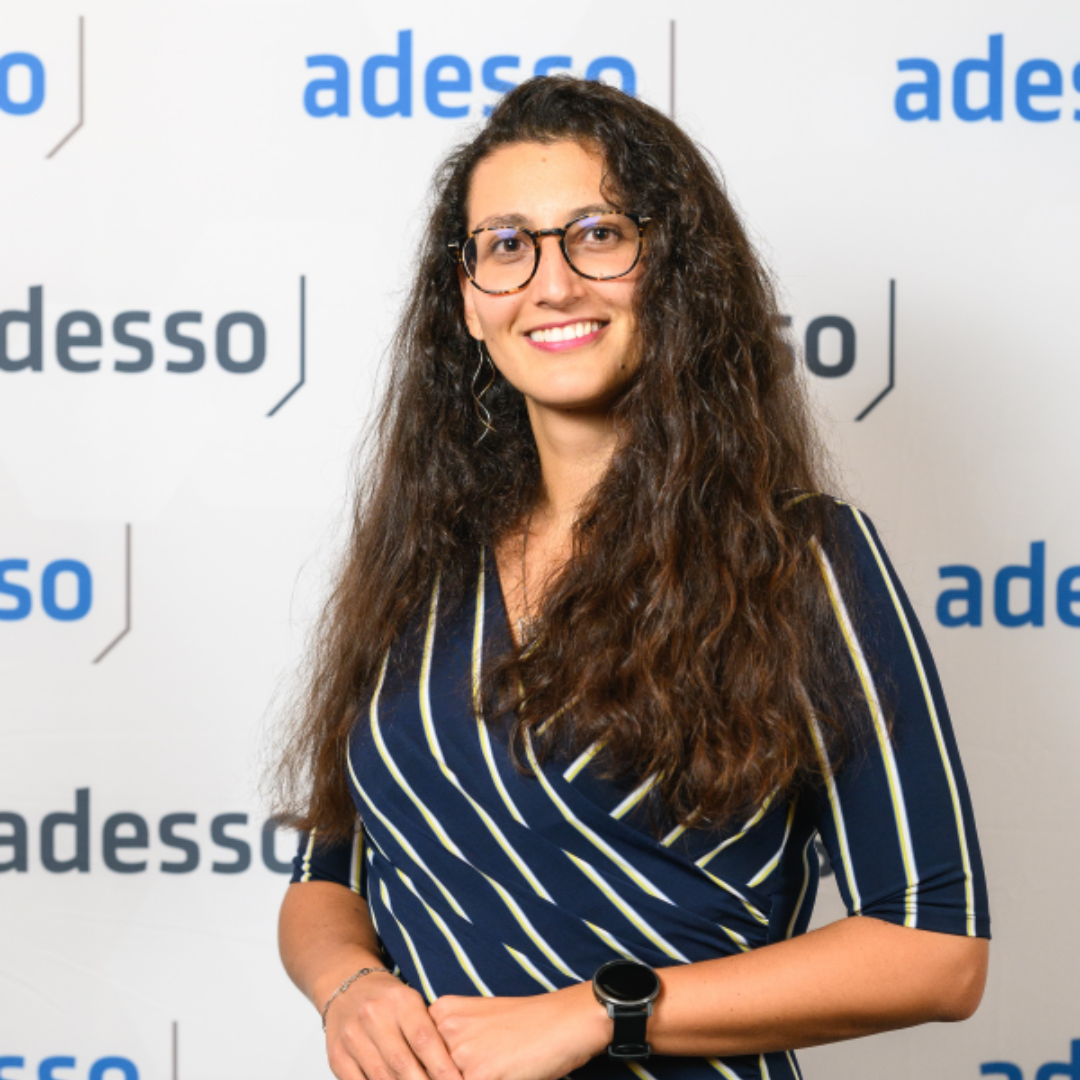 Portrait photograph of a woman with long hair, smiling.