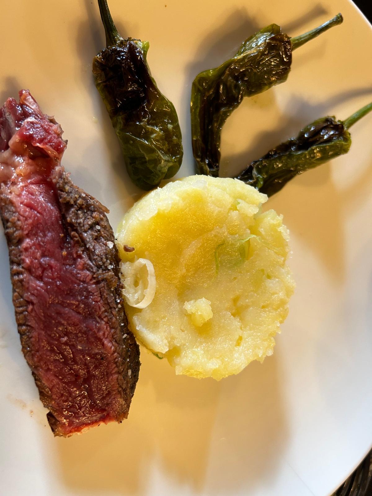 Blick nach oben auf einen Innenhof mit historischem steinernem Treppenaufgang und Fachwerkgebäude mit geöffneten Holzläden.
