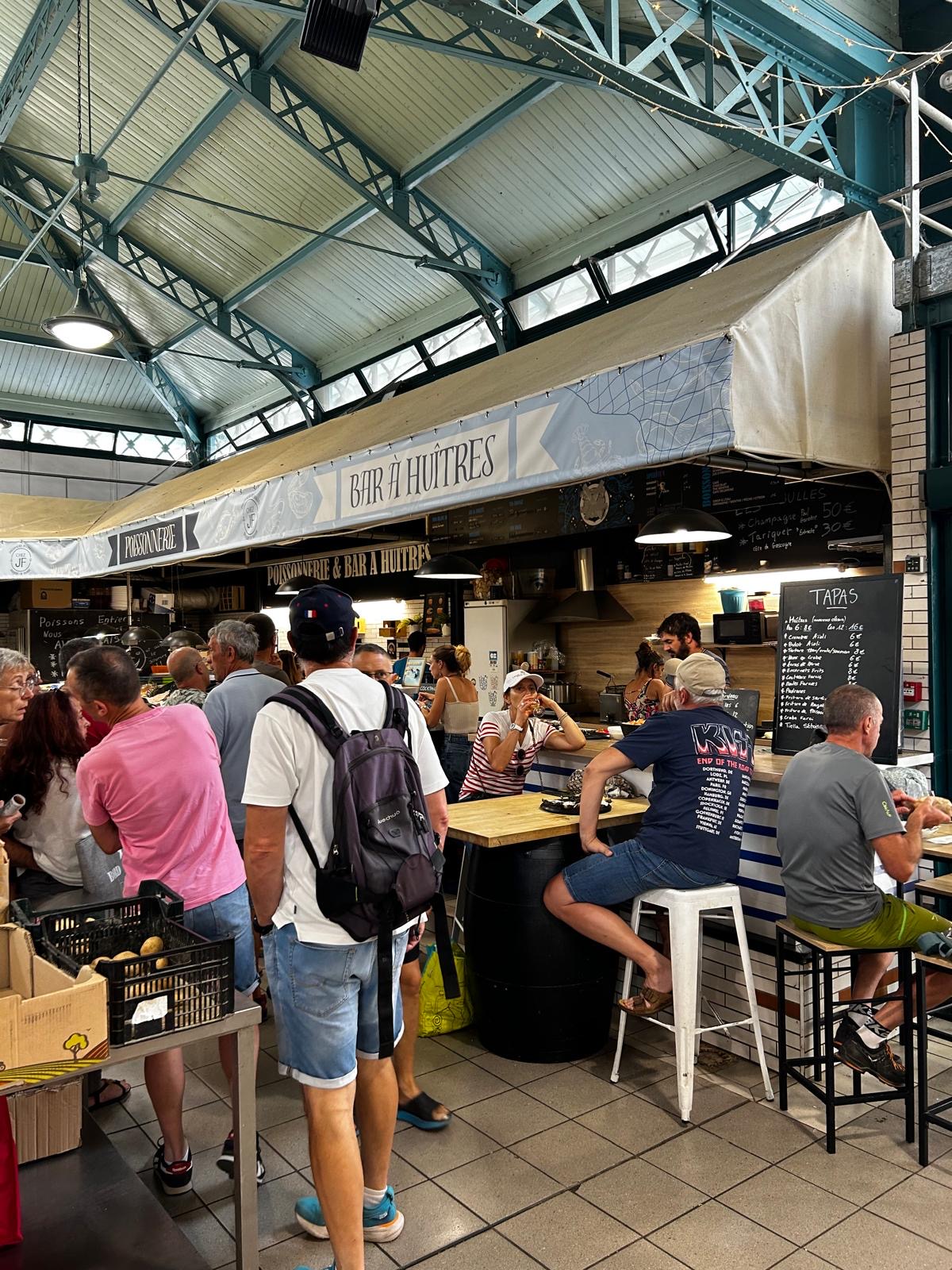 View upwards of a courtyard with a historic stone staircase and half-timbered building with open wooden shutters.
