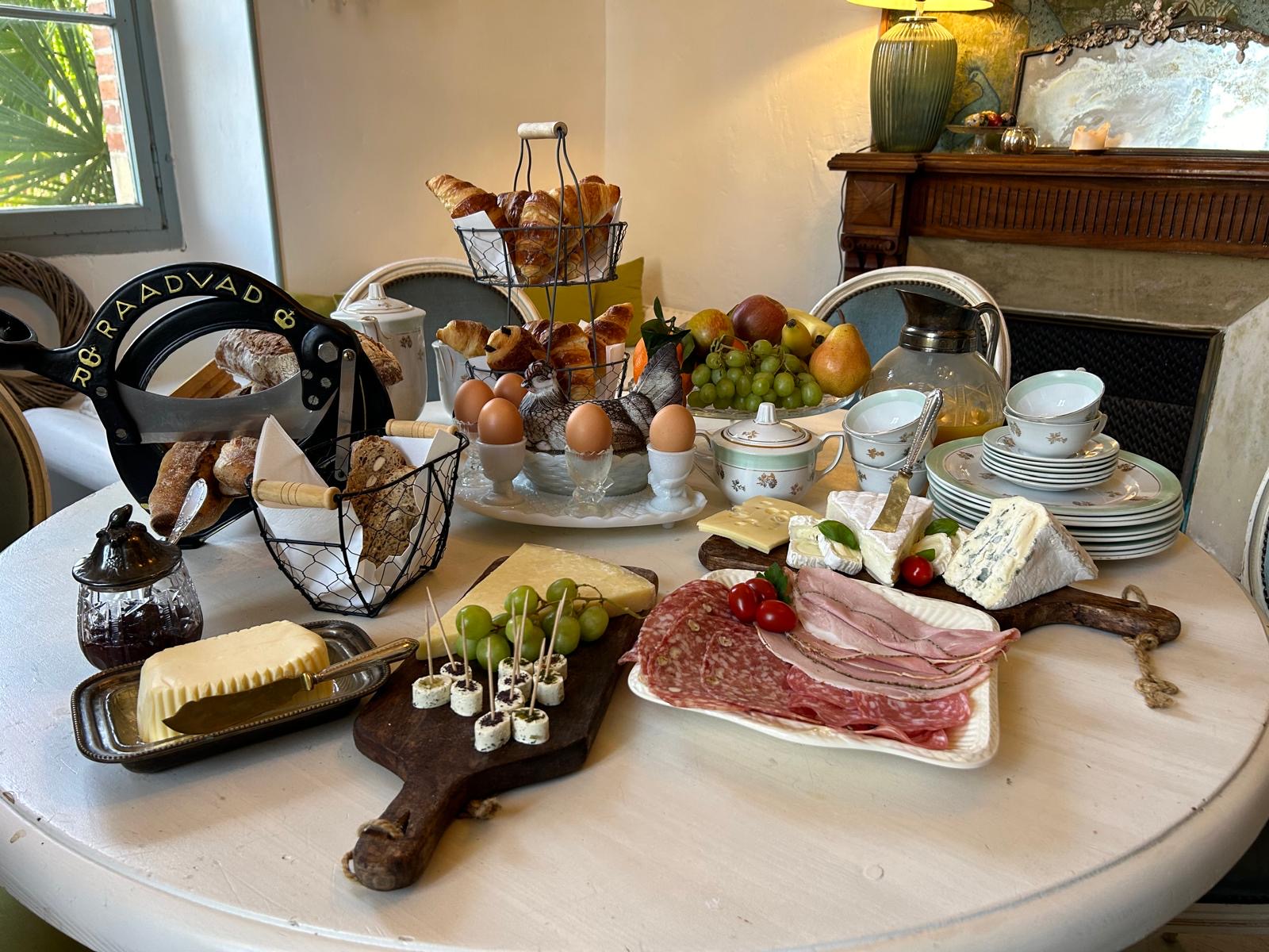 Blick nach oben auf einen Innenhof mit historischem steinernem Treppenaufgang und Fachwerkgebäude mit geöffneten Holzläden.