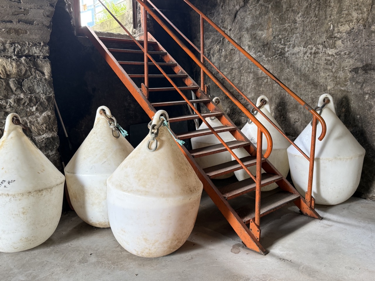 Eleganter Esstisch mit rotem Kerzenhalter, Goldrandgeschirr und Blumenvase vor dunklem Kamin mit Kranz.