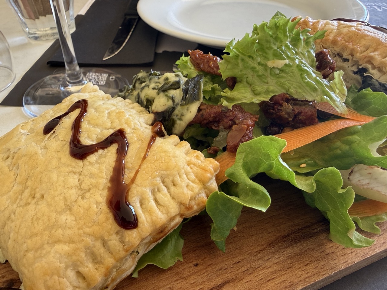 Frühstückstisch mit Croissants, gekochten Eiern in Eierbechern, Aufschnitt, Käse, Obst und Orangensaft.