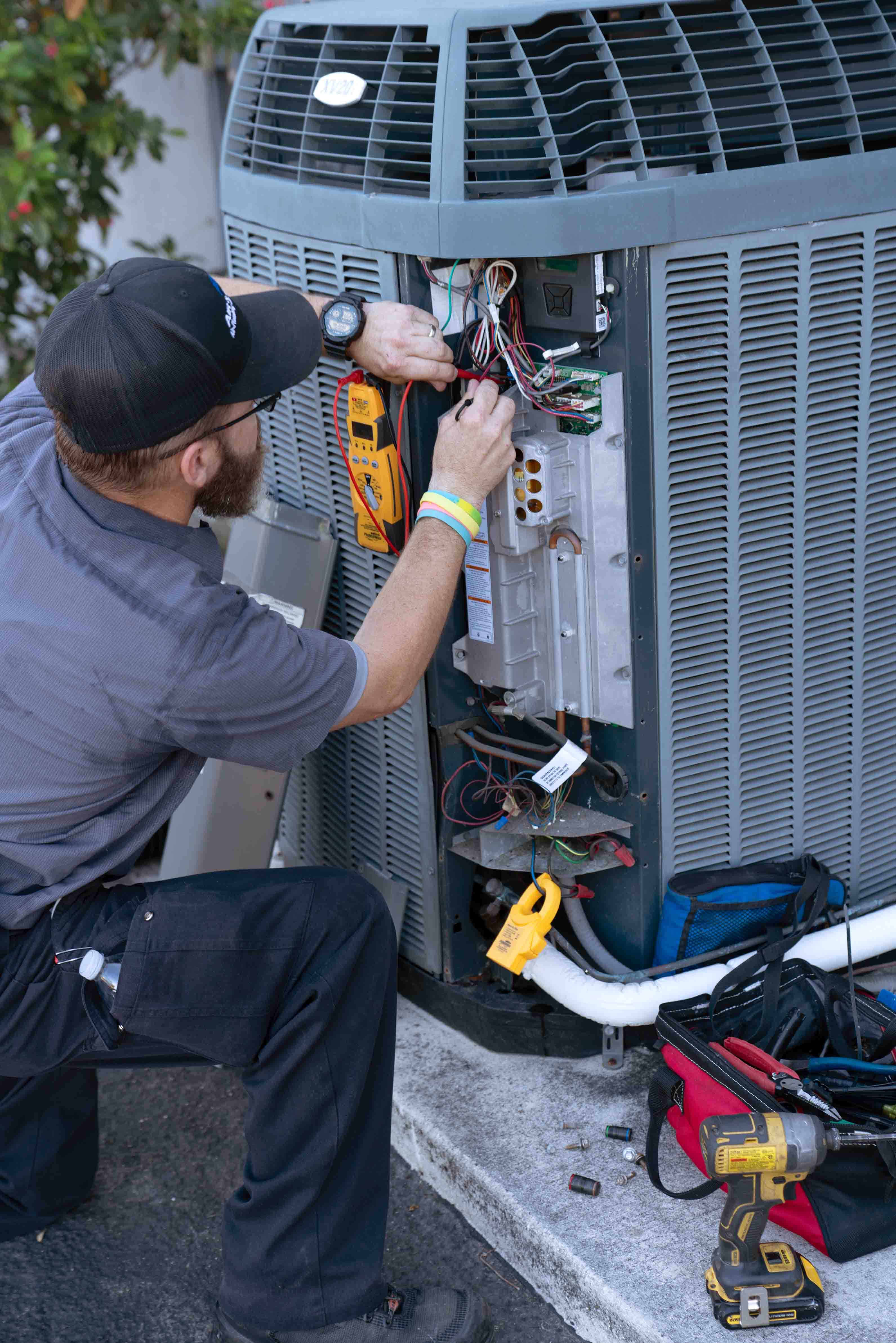 Air & Energy technician repairing AC unit