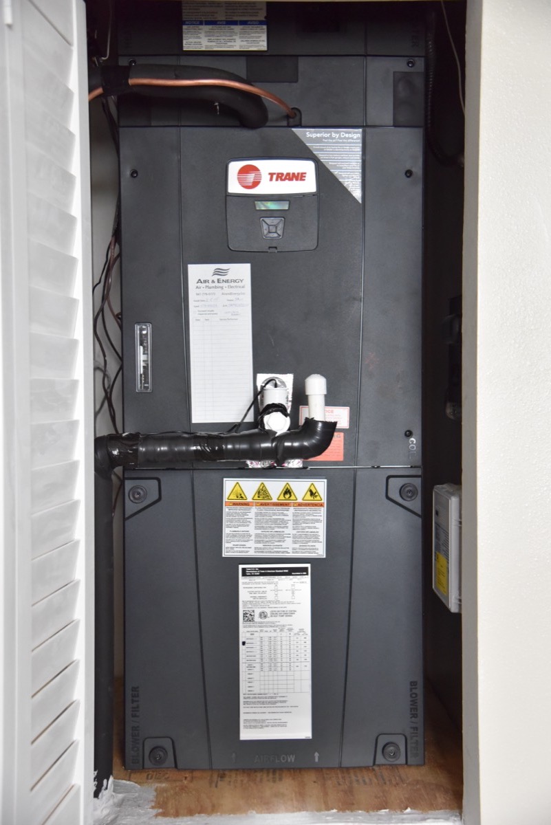 Trane air handler in a closet with an Air & Energy service tag on the front