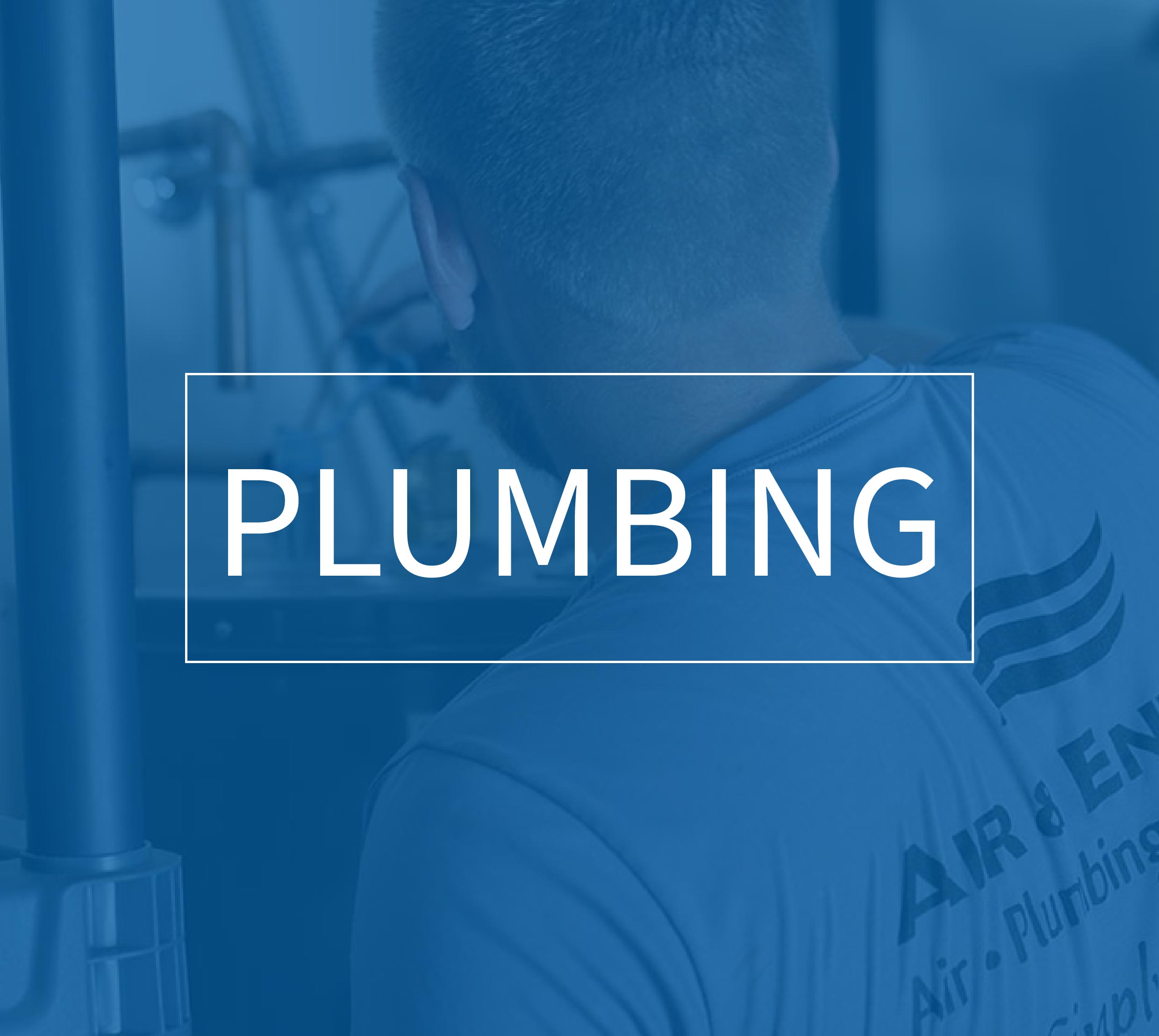 Plumber wearing a shirt with company logo working on plumbing pipes.