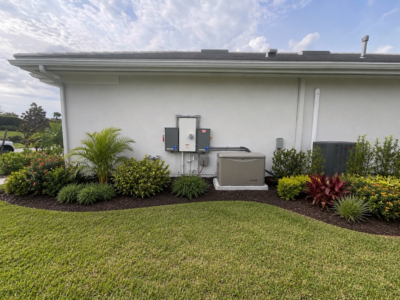 Finished Kohler whole-home generator install with ATS, conduit, and landscaping at a Bradenton home by Air and Energy