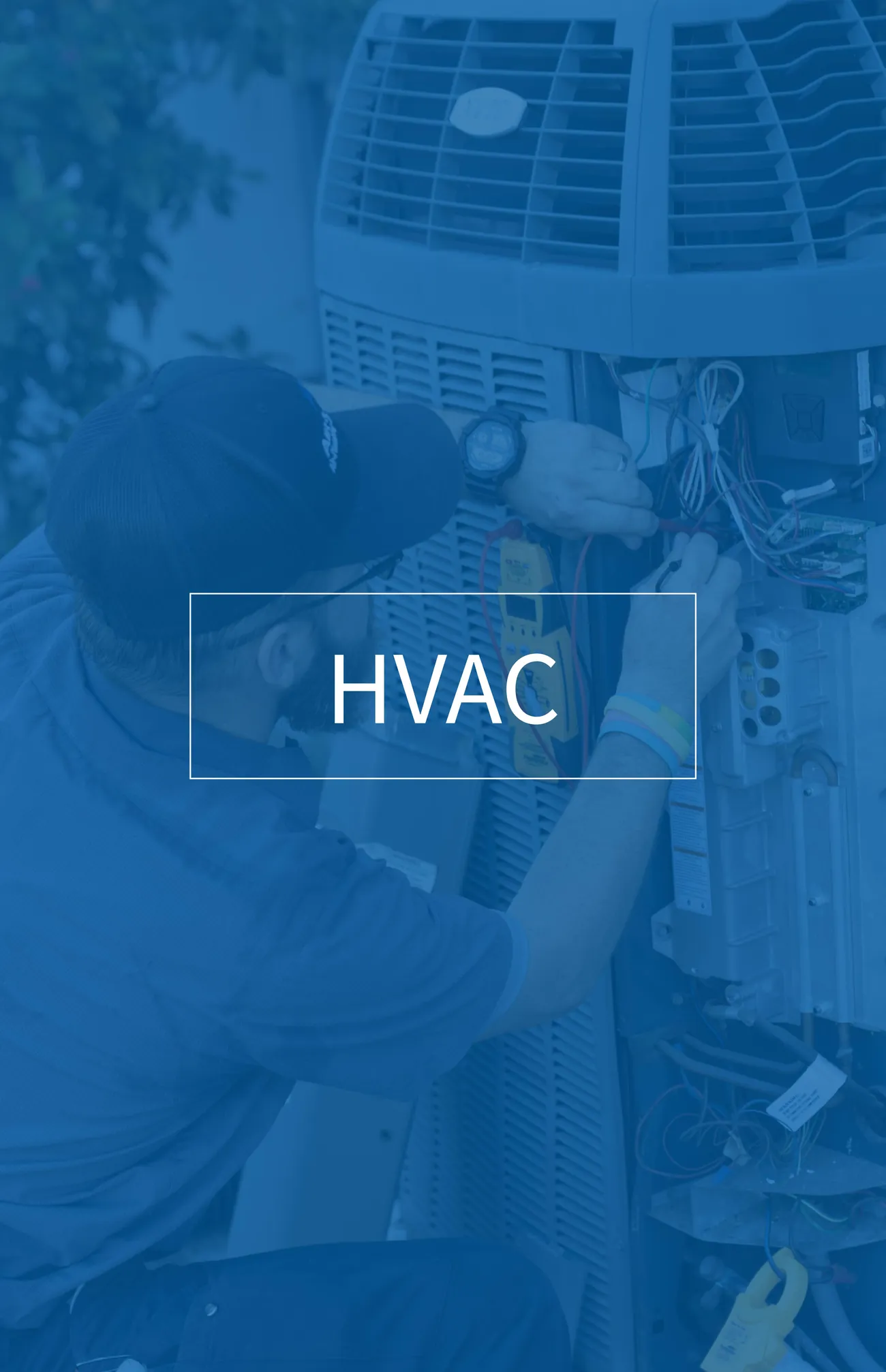 Technician wearing a cap and watch repairing an HVAC unit with exposed wiring outdoors.
