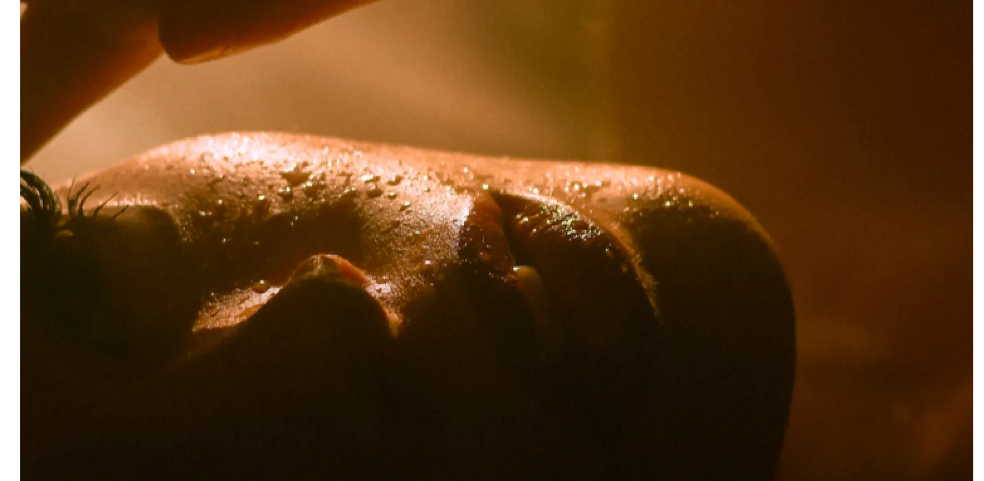 A close up of a woman's face with water droplets on her skin.