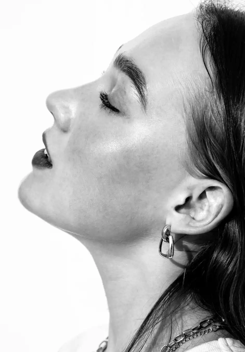 A black and white photo of a woman with her eyes closed.