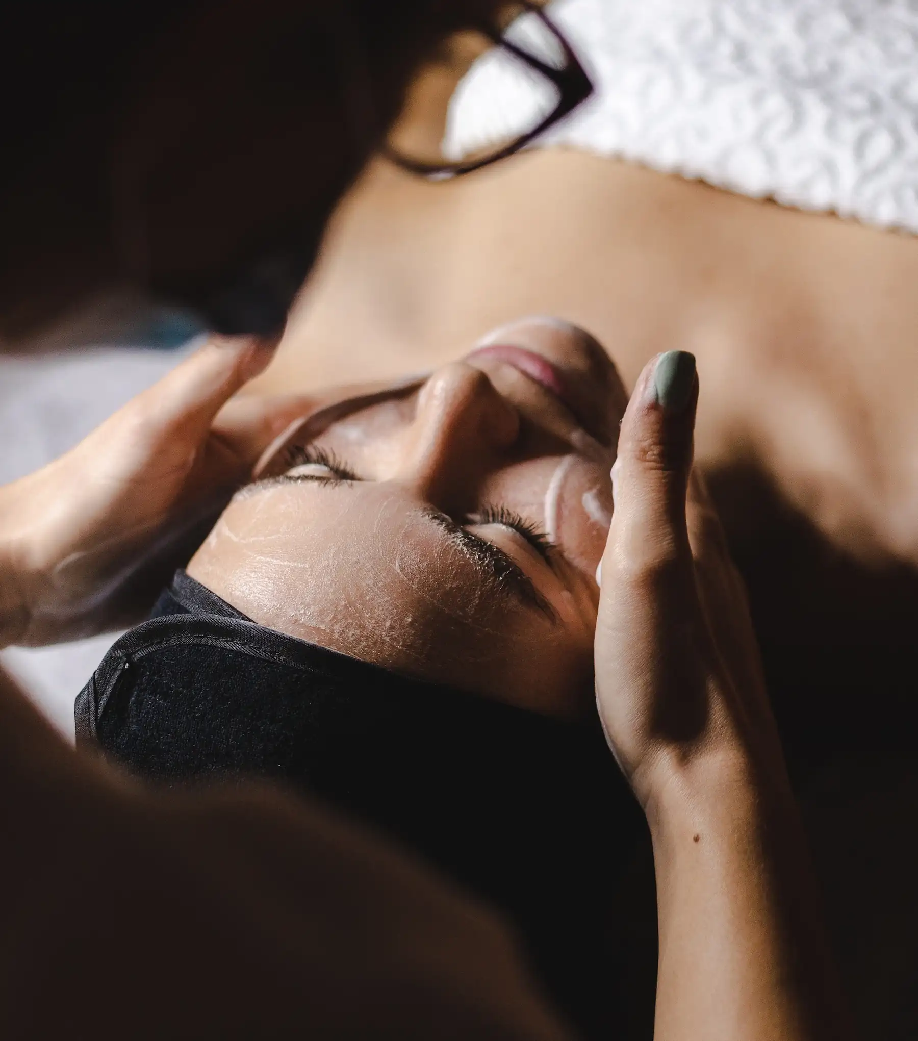 A woman laying on top of a bed holding a cell phone.